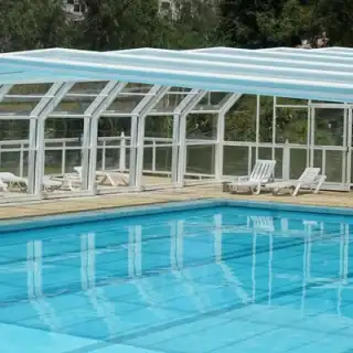 Piscine résidentielle protégée par un abri de piscine dans un jardin