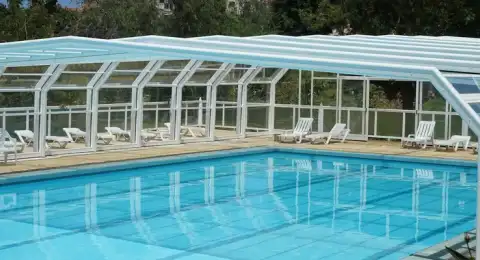 Piscine résidentielle protégée par un abri de piscine dans un jardin