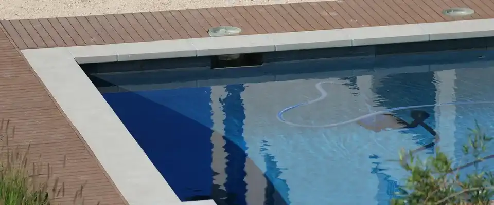 Tuyau d'aspirateur manuel plongé dans une piscine