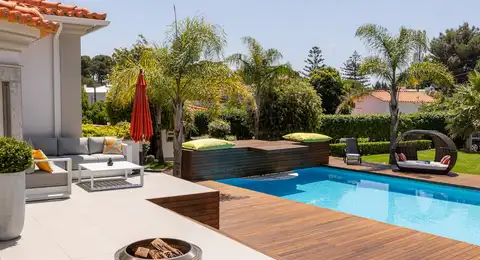 Piscine résidentielle avec terrasse en bois et salon de jardin