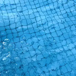 Test pH piscine avec bandelette au bord du bassin